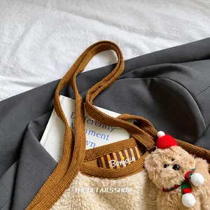 Nahaufnahme der Plüsch-Tragetasche mit Strickgriffen und süßem Weihnachts-Bär-Anhänger