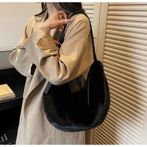 Detail of a black plush faux fur crescent shoulder bag worn with a khaki trench coat