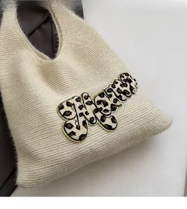 Close-up of fluffy knit tote bag with bold leopard print alphabet patchwork design
