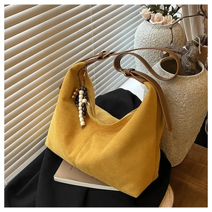 Vue détaillée du sac hobo en daim jaune avec perles en bois et bandoulière en cuir