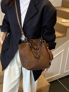 Sac seau marron en daim avec broderies, anse tressée et pompon pour un look élégant