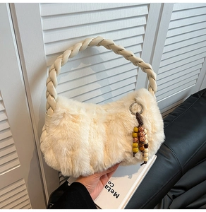 Detailed close-up of cream faux fur bag with woven handle and colorful beaded pendant