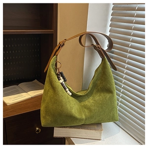 Gros plan du sac cabas en daim vert montrant la texture douce et le charme en perles de bois