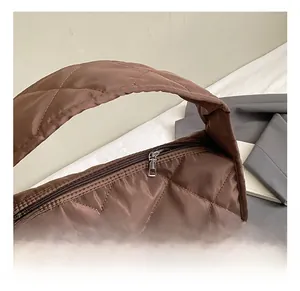 Detail of coffee brown quilted shoulder bag showing silver zipper and silk texture