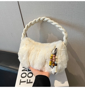 Macro detail of white faux fur handbag with woven leather handle and bohemian beaded tassel