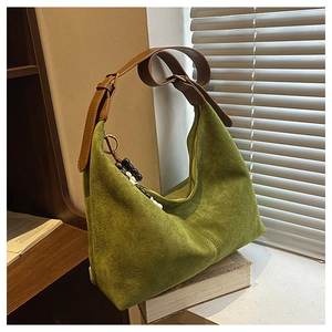 Détail du sac hobo en faux daim vert avec bandoulière marron et accessoire perlé