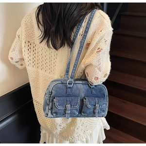Detail of vintage blue denim underarm bag with double front pockets and silver buckles