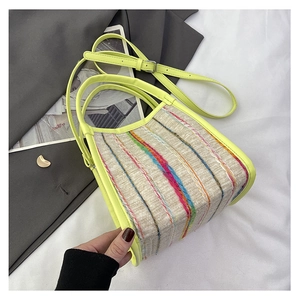 Detalle de la textura de tweed arcoíris y asa de cuero amarillo neón en un bolso elegante