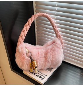 Pink faux fur handbag featuring a braided handle and ethnic bead tassel charm detail