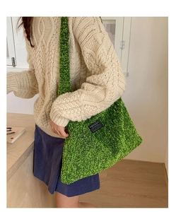 Detail van groene fleece draagtas met 'FASHION' label, gestyled met herfst gebreide kleding