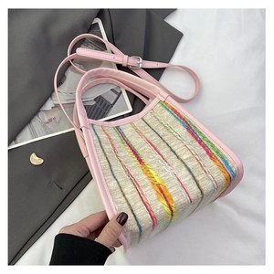 Detalle de asas de cuero rosa y tejido de rayas arcoíris en un bolso tipo shopper
