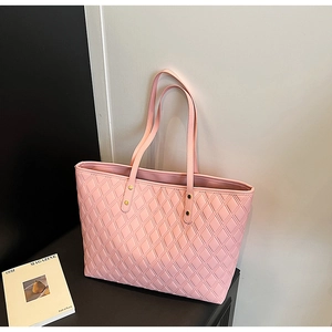 Detail of light pink quilted tote bag showing diamond stitching and gold hardware