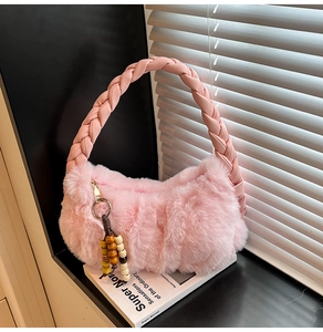 Pink plush shoulder bag featuring unique braided handles and decorative beaded charms