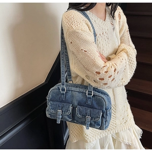 Detail view of retro denim shoulder bag with double pockets and silver metal buckles