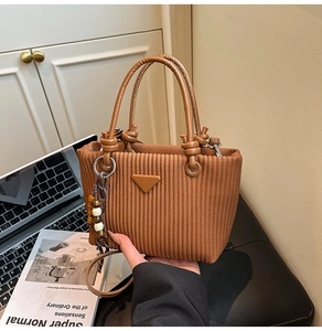 Détail du mini sac seau en velours côtelé caramel avec pompon en perles de bois
