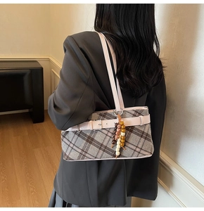 Detailed back view of a grey plaid shoulder bag with pink leather strap and wood beads