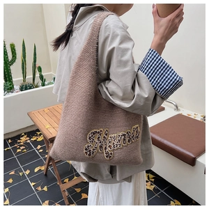 Close-up of knit tote bag featuring leopard print Mama embroidery and soft texture