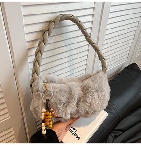 Close-up of gray plush handbag featuring woven braided handle and colorful wooden beads