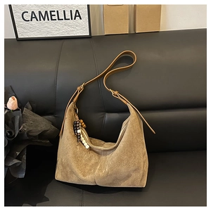 Détail du sac hobo en daim kaki avec bandoulière réglable et pendentif en perles