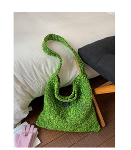 Detail van de grote groene getextureerde wollen tote tas met zwart fashion label