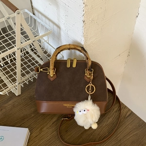 Detail of retro bamboo handles and brown suede leather on a stylish shell handbag