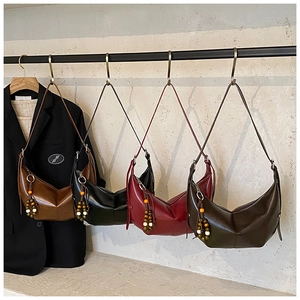 Hobo bags in caramel, black, burgundy, and green with decorative beaded tassels