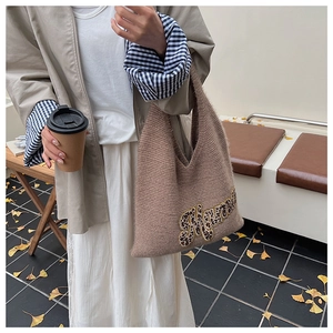 Close-up of tan knit tote bag with leopard print Mama text in an outdoor autumn setting