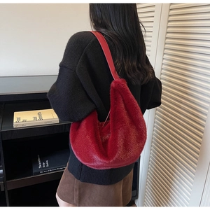 Detailed back view of a plush red fuzzy hobo bag with a soft faux fur texture and long strap