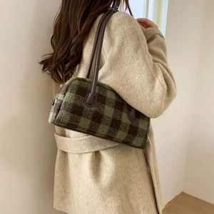 Grand cabas en laine à carreaux vert et marron porté avec un manteau en laine blanc élégant