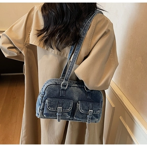 Detail of vintage blue denim underarm bag featuring silver buckles and cargo pockets