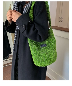 Detail der neongrünen Plüsch-Tasche mit Fashion-Patch auf schwarzem Wollmantel
