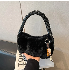 Close-up of black faux fur handbag with braided leather handle and boho beaded charm