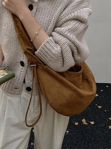 Minimalist brown suede hobo bag with drawstring and adjustable metal buckle on shoulder