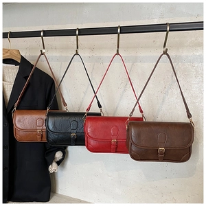 Detail view of retro shoulder bags in four colors hanging on a minimalist display
