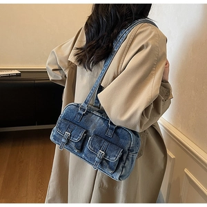 Detail of vintage blue denim shoulder bag with double pockets and metal buckles