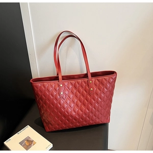 Close-up of red quilted tote bag featuring elegant diamond stitching and sleek texture
