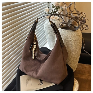 Détail du sac hobo en daim marron café avec fermeture perlée et bandoulière en cuir