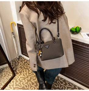 Détail du sac seau plissé marron avec perles en bois et ruban décoratif à pois
