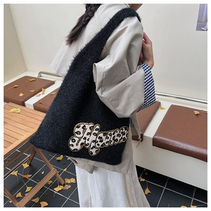 Detail of black faux fur tote bag with leopard print Home letter embroidery