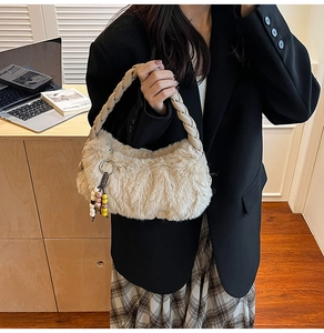 Detailed shot of beige plush handbag with braided handles and colorful beaded charm