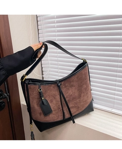 Detail of vintage brown suede hobo bag with black leather trim and adjustable strap