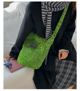 Detaillierte Textur der grünen Plüsch-Beuteltasche mit schwarzem Fashion-Etikett