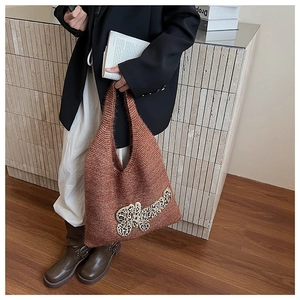 Detailed knit texture of a brown tote bag featuring a leopard print Mama patch design