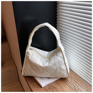 Detail of white quilted nylon shoulder bag showing rhombus pattern and wide strap