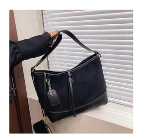 Detail of black suede and leather bucket bag with wide strap and mini coin purse