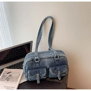 Detail of vintage blue denim shoulder bag with dual utility pockets and metal buckle hardware
