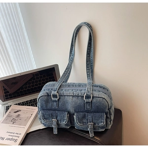 Close-up of vintage blue denim shoulder bag with double front flap pockets and Y2K style