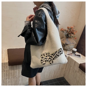 Detail shot of the large white knit tote bag featuring a leopard print letter patch