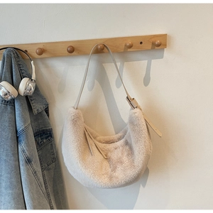 Detail of adjustable PU strap and buckle on a beige plush faux fur crescent shoulder bag