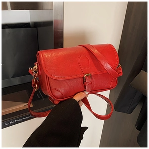 Close-up of red lychee pattern PU leather crossbody bag with golden needle buckle